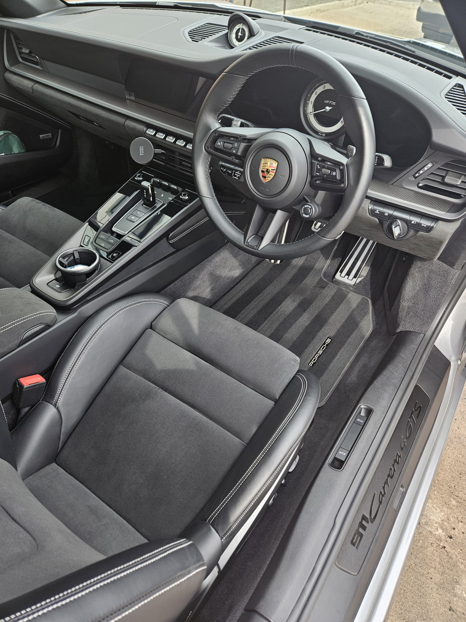 Porsche 911 interior showing steering wheel, seats and console after detailing