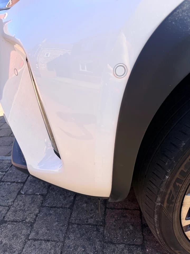 The same white vehicle panel after the surface marks were treated
