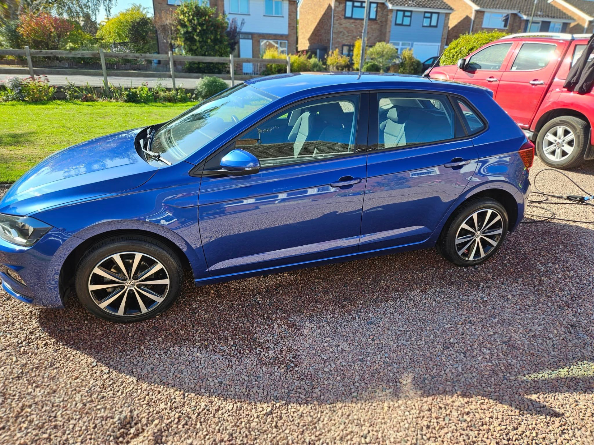 Blue Volkswagen Polo cleaned on a gravel driveway
