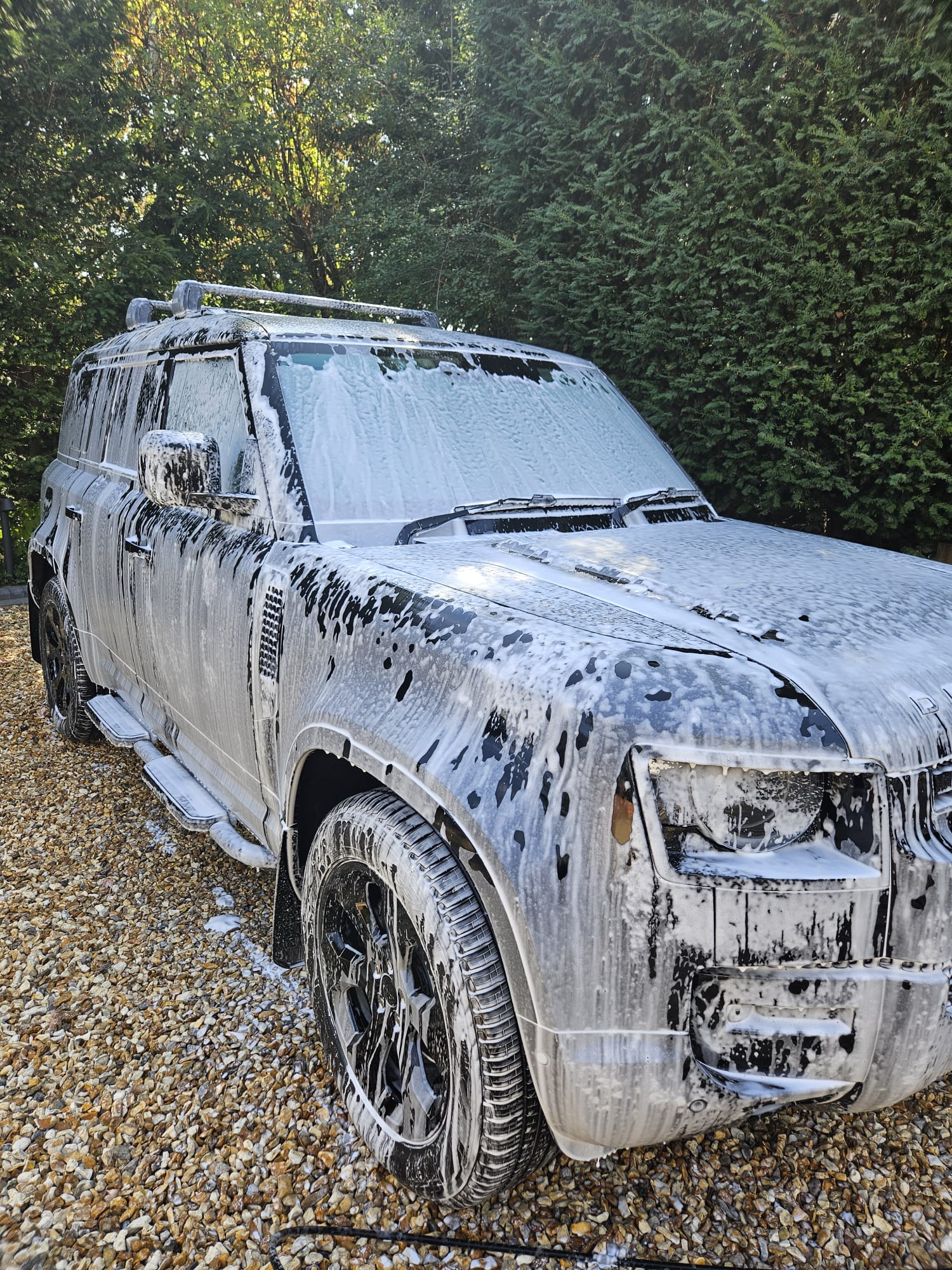 Land Rover Defender covered in snow foam during washing