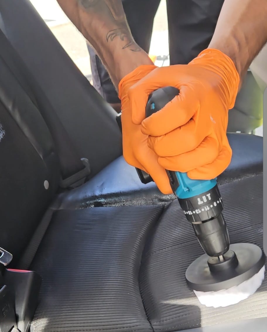 Machine cleaning a vehicle seat during an interior detail