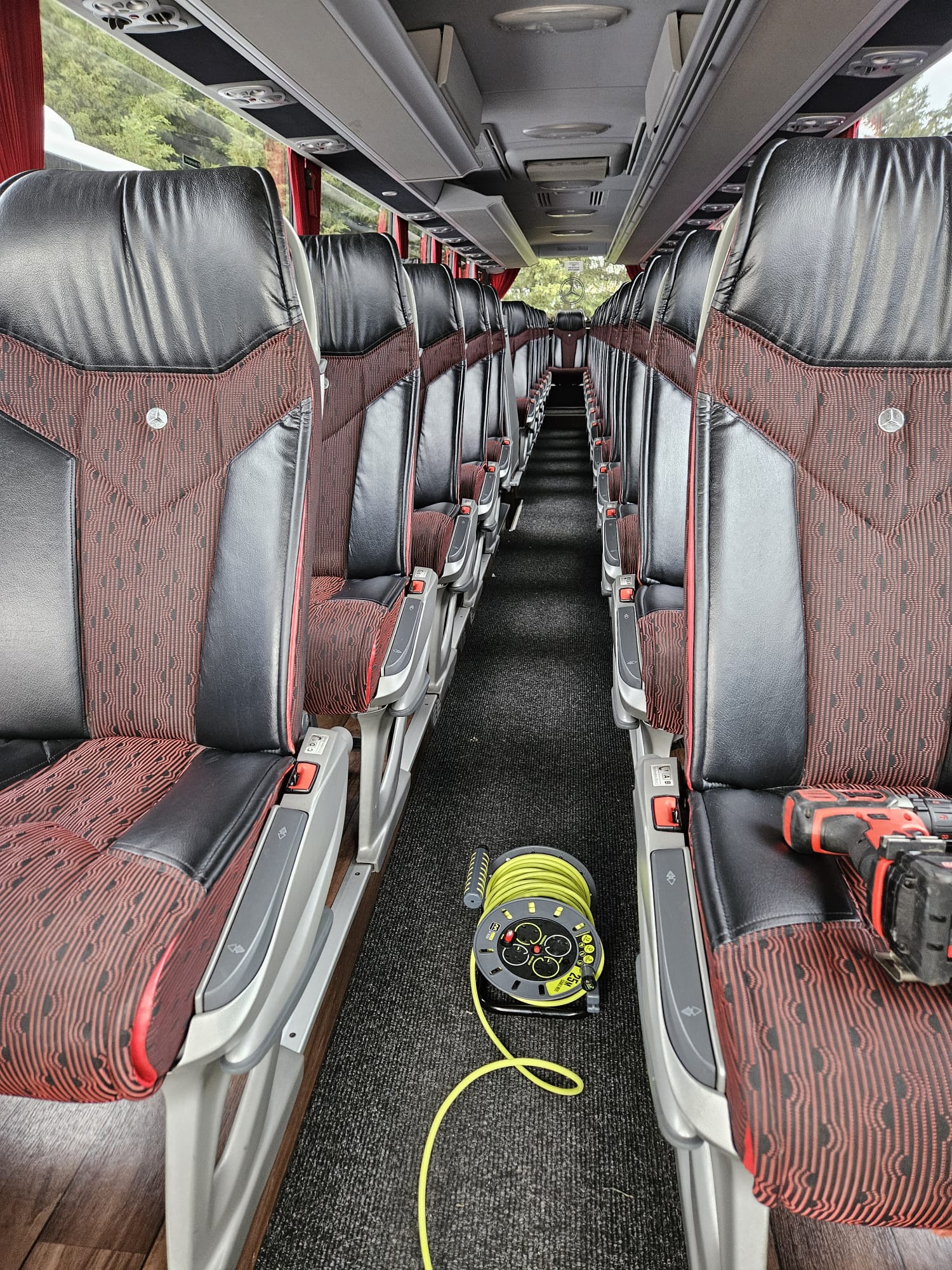 Interior of a coach with red seats and cleaned aisle carpet